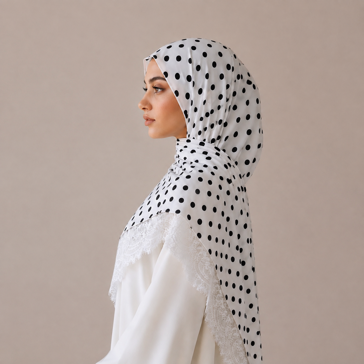 Voile Nour pois ivoire en modal, bordure dentelle, plié sur fond beige